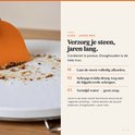 Oranje deegschraper die kruimels van een witte steen schraapt.