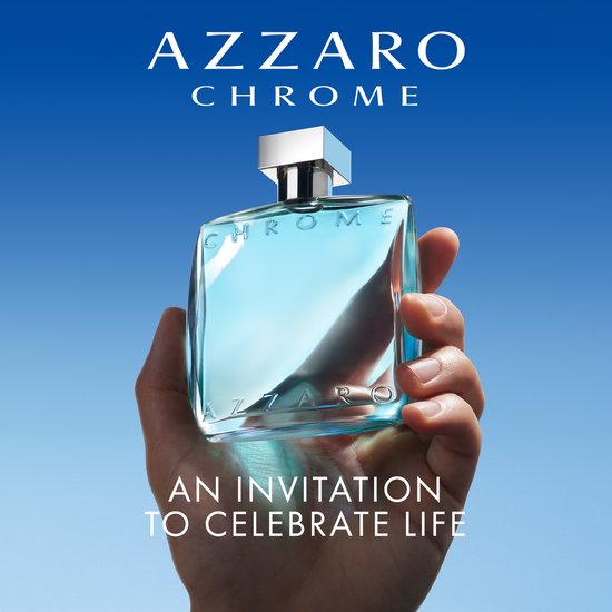 Hand houdt Azzaro Chrome Eau de Toilette fles omhoog met blauwe achtergrond.