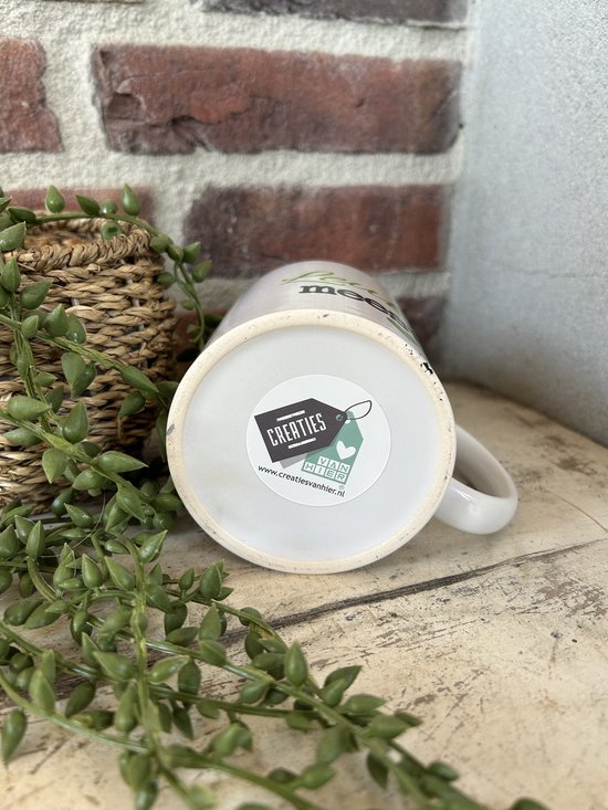 Onderkant van een witte mok met logo's en website "www.creatiesvanhier.nl".