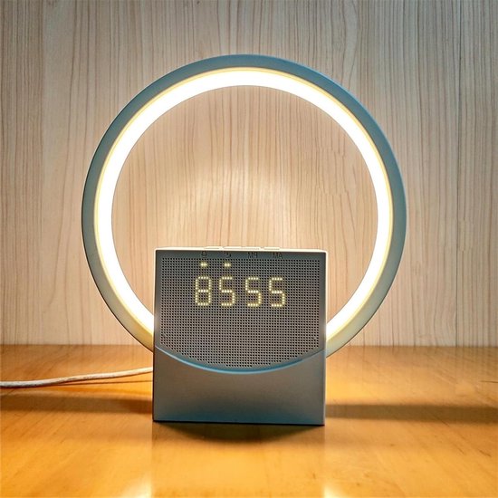 Witte wekker met blauwe ringlamp en digitaal display dat 05:55 weergeeft, op een houten tafel.