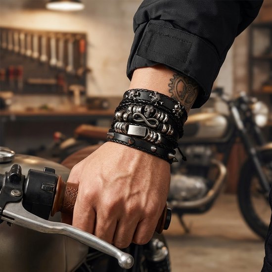 Een man in een leren jas, met tatoeages, draagt meerdere zwartleren armbanden met metalen schedels en oneindigheidssymbolen.