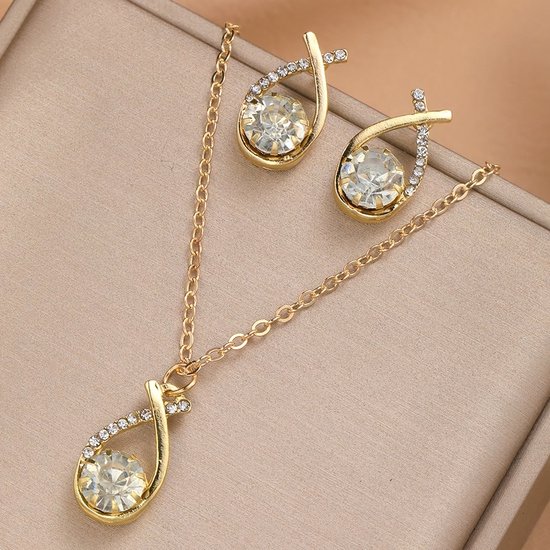 Goudkleurige ketting en oorbellen met druppelvormige kristallen en strass.