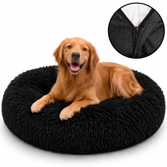 Golden retriever dans un lit pour chien noir et duveteux.