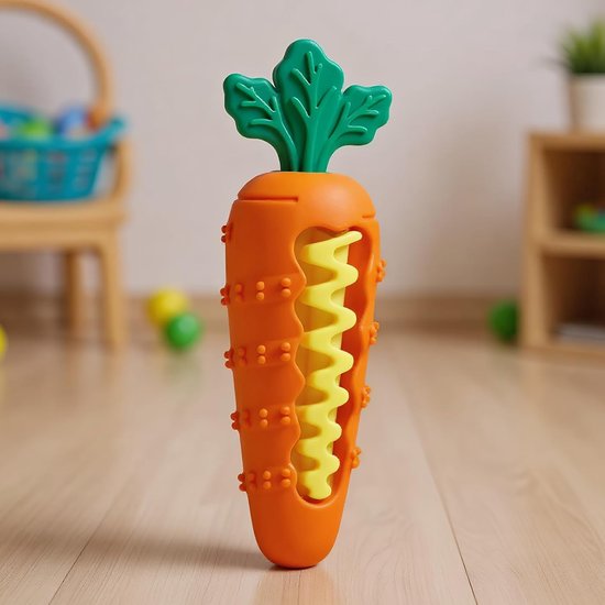 Oranje wortelspeeltje met groen blad en geel zigzag-element, op een houten vloer.