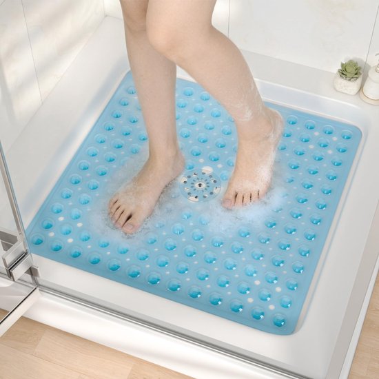 Voeten op een blauwe douchemat met noppen, omringd door schuim en water.