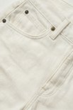 Close-up van de voorkant van een witte spijkerbroekshort met wijde pijpen, met focus op de zakken.
