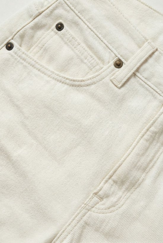 Close-up van de voorkant van een witte spijkerbroekshort met wijde pijpen, met focus op de zakken.