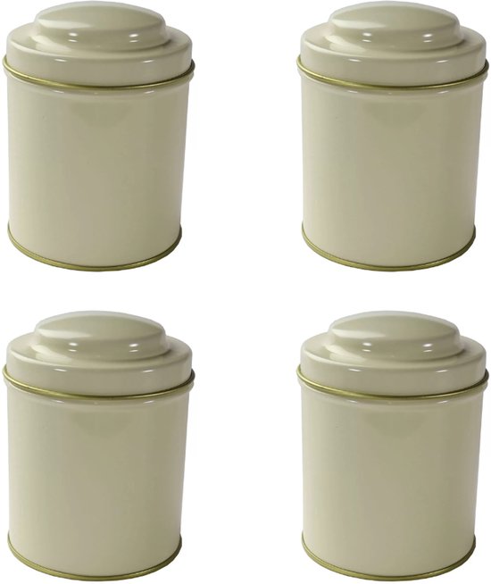 Vier crèmekleurige, cilindervormige blikken met een goudkleurig randje en een ronde deksel.
