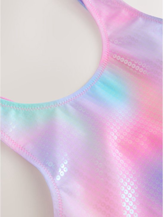 Detail van het badpak: veelkleurige tie-dye print met glinsterende pailletten.