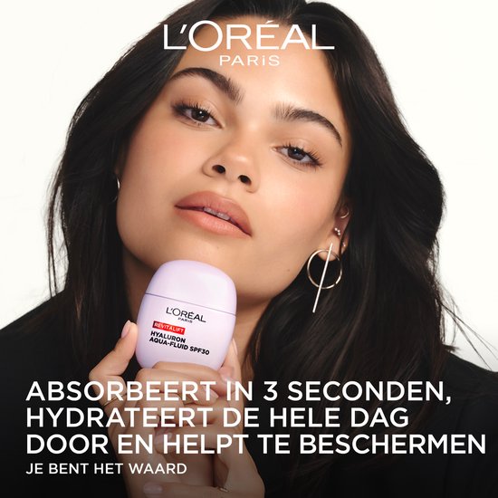 Een jonge vrouw met een paars L'Oréal Revitalift Hyaluron Aqua-Fluid SPF30 flesje.