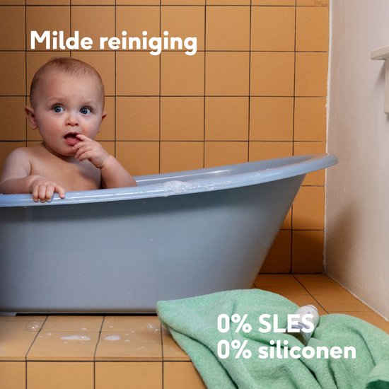 Baby in bad met zachte handdoek. Tekst: "Milde reiniging" en "0% SLES 0% siliconen".