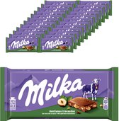 Doos van 24 Milka repen met hazelnoten, elk met paarse verpakking en afbeelding van een koe.