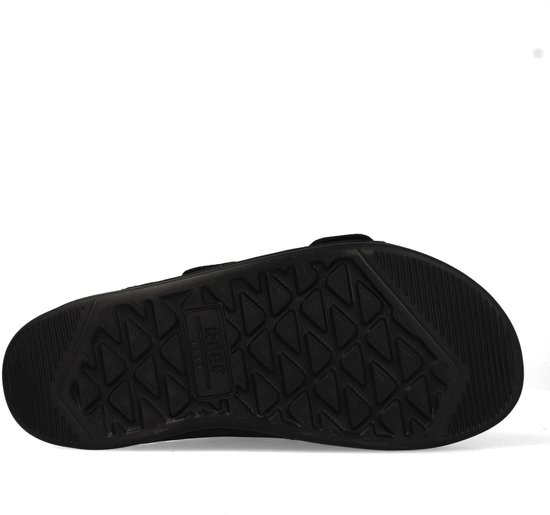 Onderkant van een zwarte Reef slipper met driehoekig profiel.
