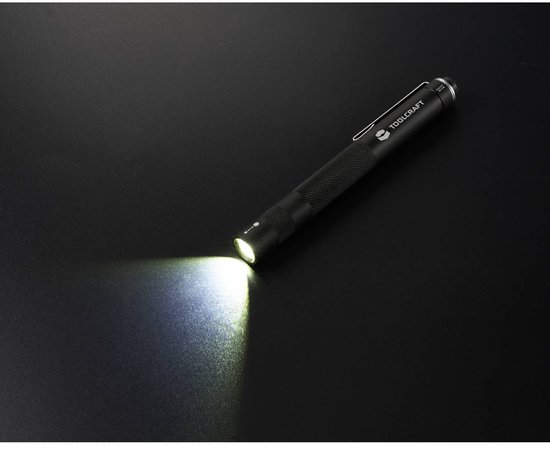 Lampe torche noire texturée projetant une lumière vive sur fond sombre.