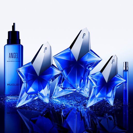 Een collectie van drie Mugler Angel Stellar sterflacons en een navulflacon, omringd door blauwe glitter.