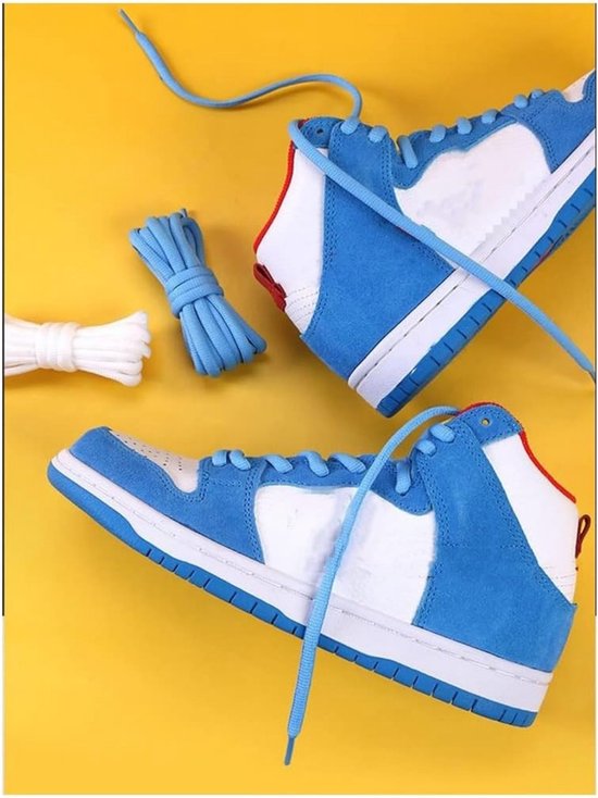 Baskets montantes bleues et blanches avec des accents rouges, avec des lacets bleus et blancs à côté.