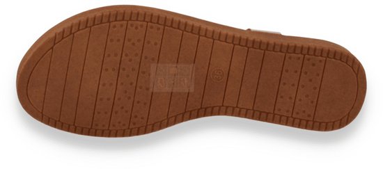 Onderkant van een gouden sandaal met antislip noppenpatroon.