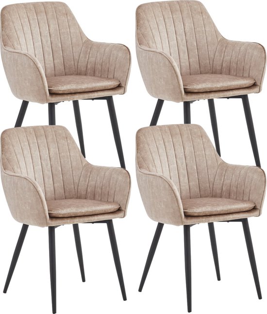 Vier champagnekleurige eetkamerstoelen met fluwelen bekleding, verticale stiksels en zwarte metalen poten.