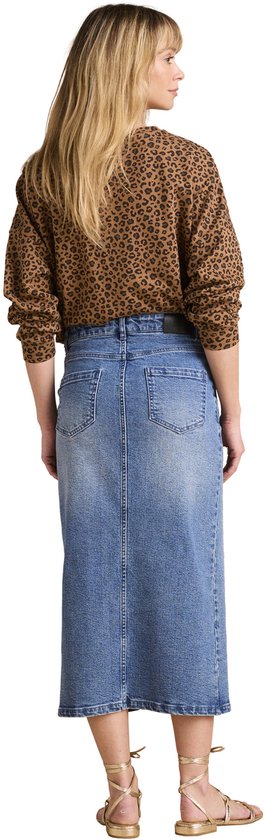 Achterkant van een model in een lange blauwe spijkerrok met split vooraan en een luipaardprint top.
