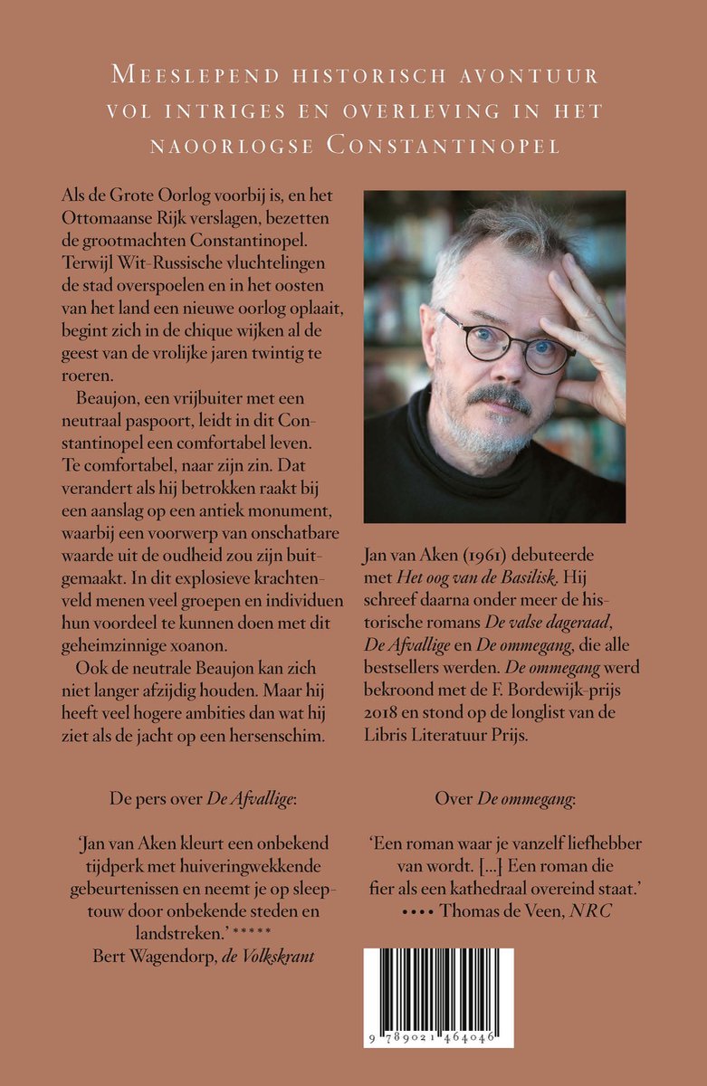 Portret van auteur Jan van Aken, met bril en grijzend haar, bij het omslag van zijn boek 'Het Xoanon'.