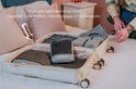 Grijze packing cubes van The Traveling Kid, georganiseerd in een open koffer. Geschikt voor koffers, handbage en backpacks.