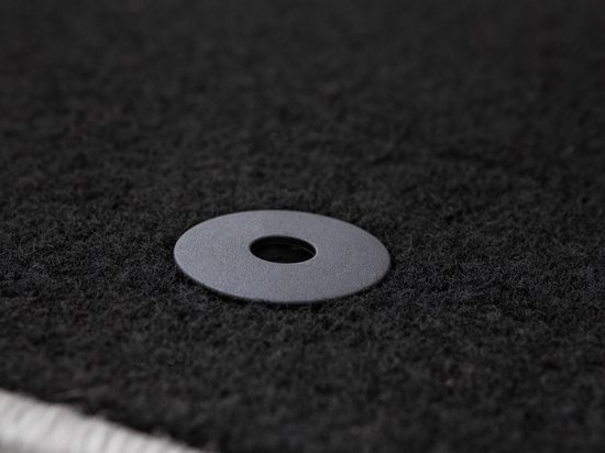 Anneau rond en plastique gris comme fixation sur un tapis noir.