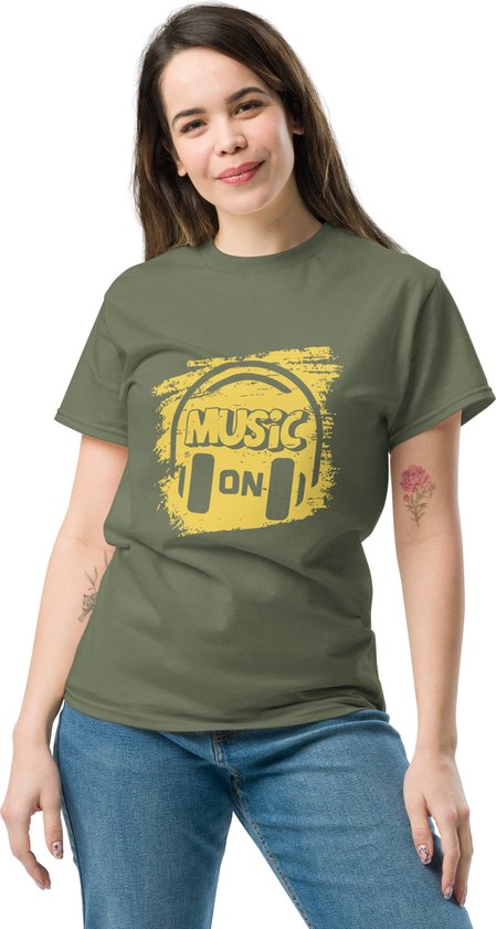 Vrouw in een kaki groen T-shirt met gele 'Music On' koptelefoonprint. Jeans.