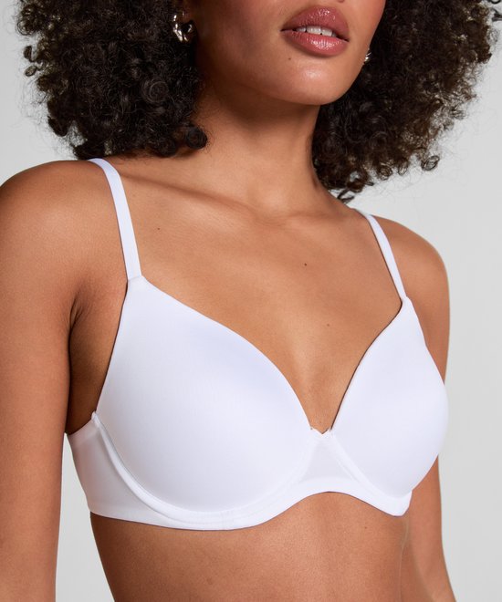 Close-up van witte beha met voorgevormde cups en bandjes.