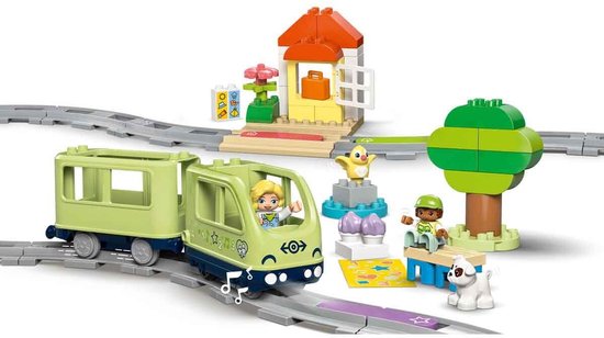 Train LEGO Duplo avec wagons vert clair, maisonnette, arbre, figurines et chien.