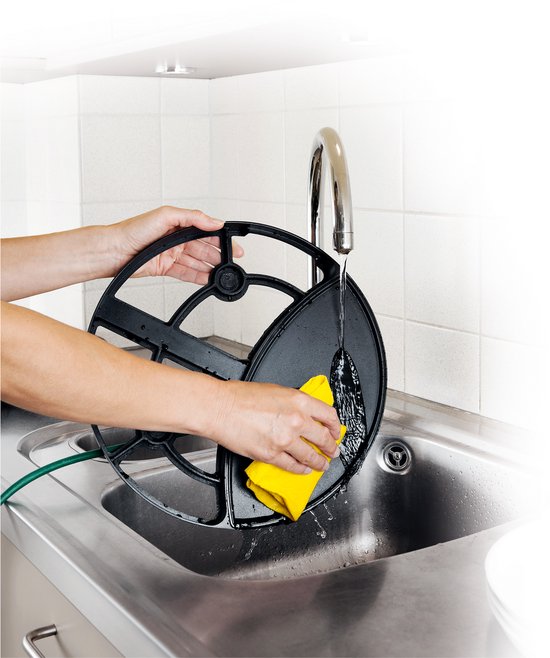 Handen die de zwarte bakplaat van de Princess gourmetset schoonmaken in een gootsteen.