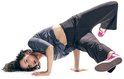 Vrouw in donkergrijze top en broek, dansend op de grond, met roze sneakers.