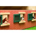 Houten paardenstal, close-up van paardenkoppen uit de ramen met groene luiken.