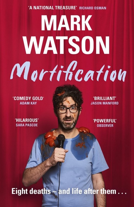 Boek "Mortification" van Mark Watson, met een man in blauw shirt met tomatensaus, die een microfoon vasthoudt.