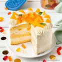 Gâteau avec glaçage blanc et décoration HARIBO, avec quelques oursons HARIBO à côté.