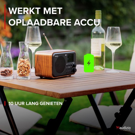 DAB radio met houtlook op een tuintafel met wijn, glazen en de tekst 'Werkt met oplaadbare accu'.