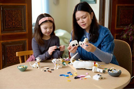 Een vrouw en een meisje bouwen samen aan LEGO Dalmatiërs.