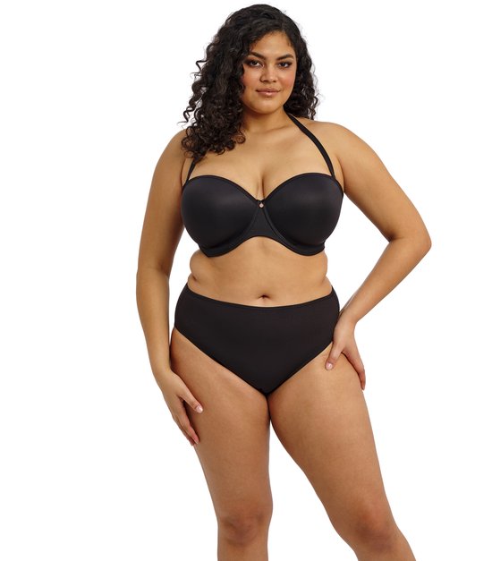 Mannequin pulpeux portant un soutien-gorge bandeau noir avec une bretelle tour de cou et une culotte noire assortie.