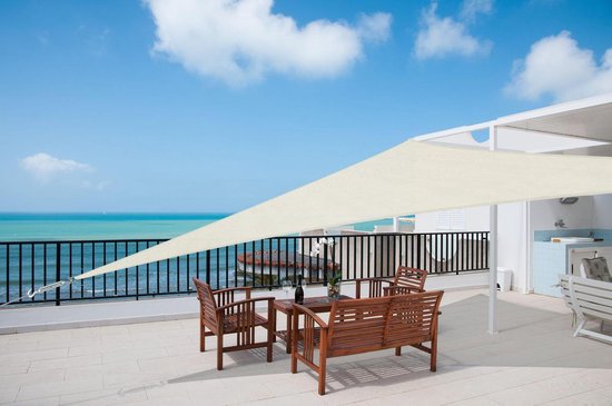 Crème driehoekig schaduwdoek boven een houten zitje op een terras met uitzicht op zee.