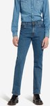 Model in blauwe spijkerbroek en denim overhemd, zwarte schoenen.