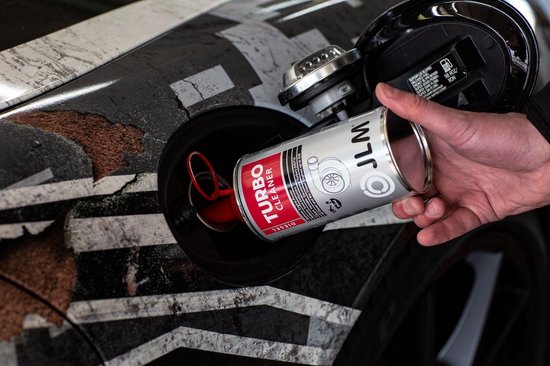 Hand giet JLM Diesel Turbo Cleaner uit zilveren fles in een moderne auto met een gestreepte motorkap.