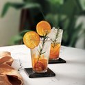 Deux verres Duralex Picardie transparents avec cannelures verticales, remplis d'eau glacée et de rondelles d'orange avec du romarin.