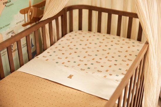 Ledikant met een hoeslaken met een subtiele dierenprint van konijnen, nijlpaarden en beren. Het hoeslaken is wit met beige.