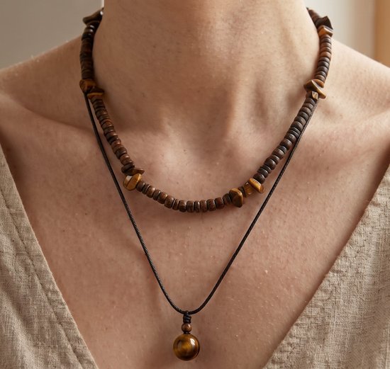 Collier superposé avec perles en bois brun, accents œil-de-tigre et pendentif bille œil-de-tigre sur cordon noir.
