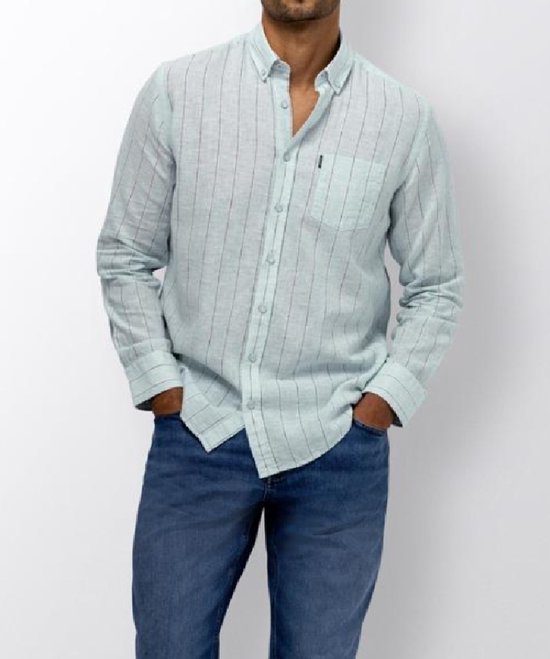 Model draagt een lichtblauw linnen overhemd met verticale strepen, een borstzak en knoopsluiting, gecombineerd met jeans.