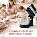Een gezin bakt samen met een zwarte Broba mixer met metalen kom, omringd door ingrediënten.