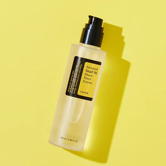 COSRX Advanced Snail 96 Mucin Power Essence, 100 ml. Doorzichtig product in frosted fles met zwarte pompdispenser op gele achtergrond.