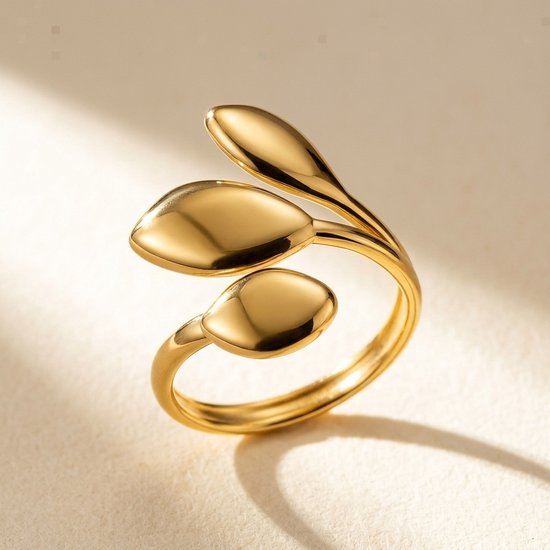 Gouden ring met drie blaadjes, gepolijst roestvrij staal op een lichte achtergrond.