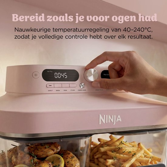 Roze Ninja airfryer met glazen schalen, digitaal bedieningspaneel bovenaan en hand die de instelknop aanpast.
