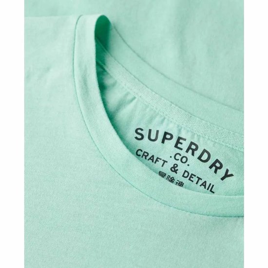 Gros plan sur le cou d'un t-shirt Superdry vert d'eau avec étiquette.