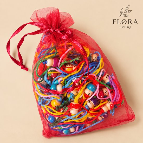 Veelkleurige houten gelukspoppetjes verpakt in een rood organza zakje van FLØRA Living.
